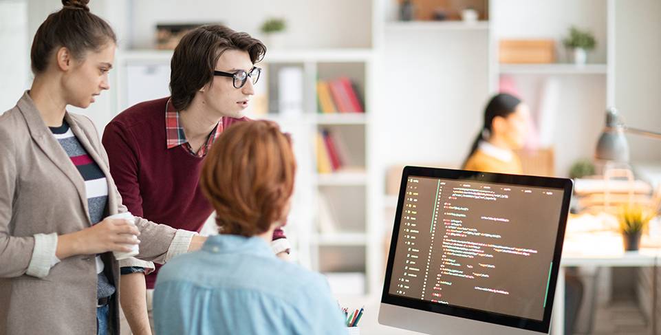 Three people reviewing code on screen